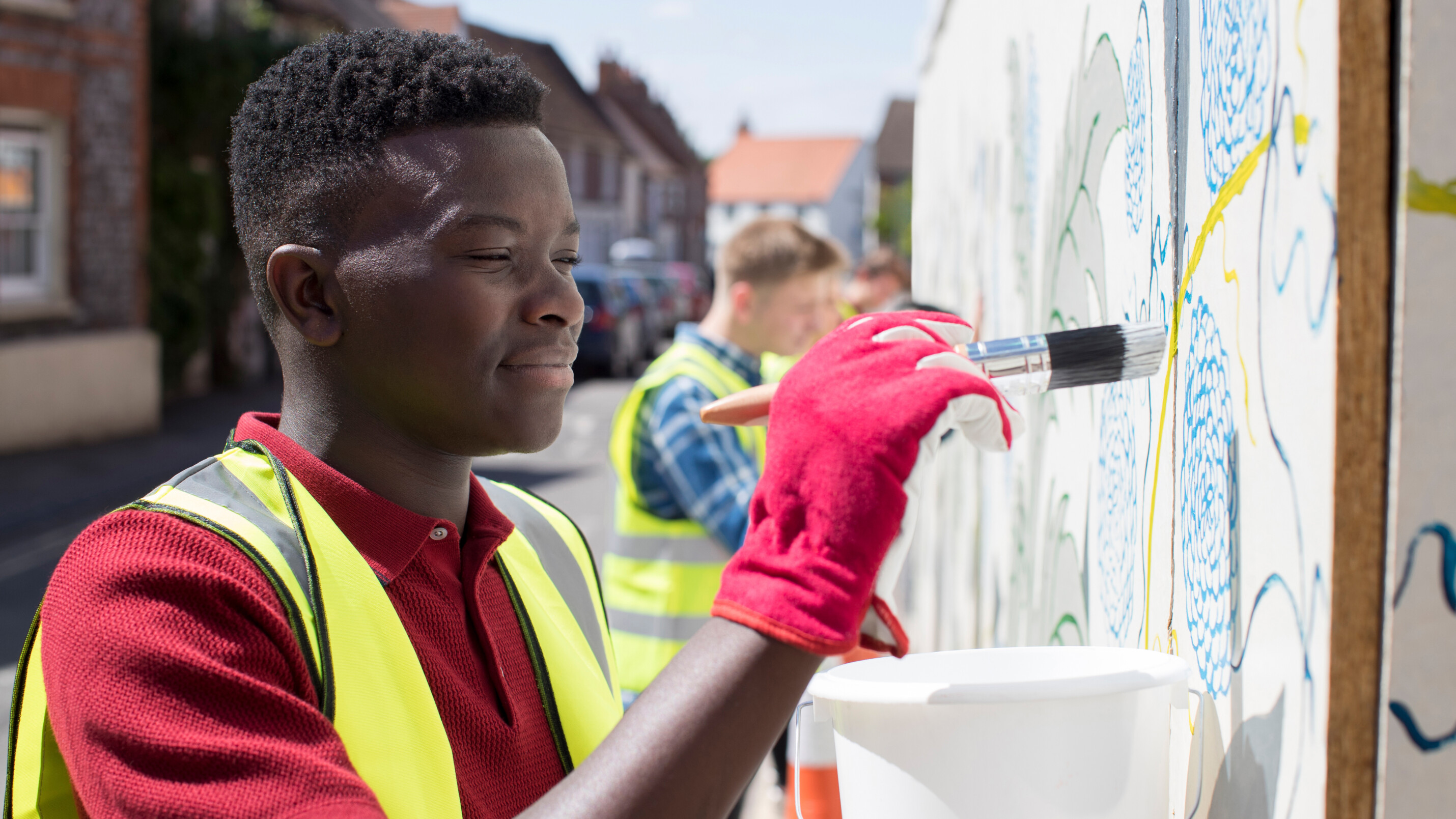 Teenager paints mural in community art project