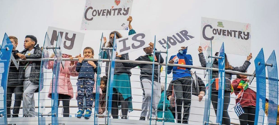 Group holds signs that read "My Coventry is your Coventry"