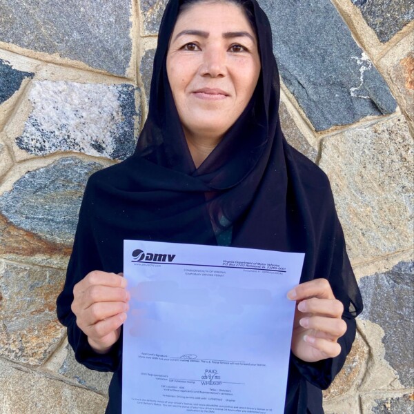 A client from Afghanistan smiles with her learner's permit