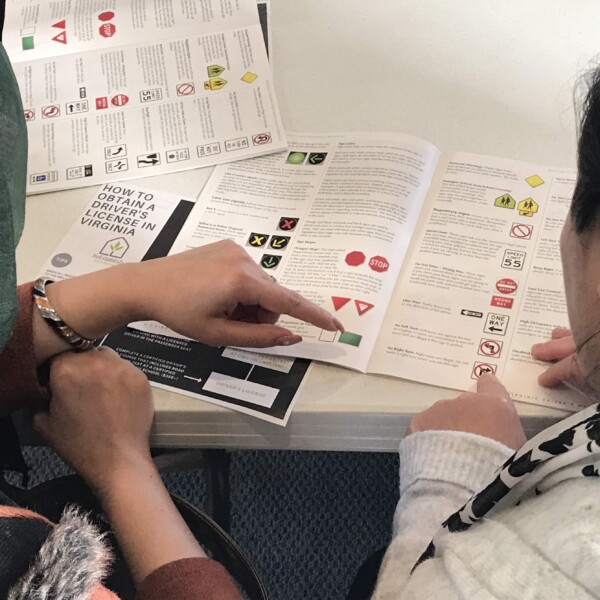 Clients review the drivers manual during a class taught in Dari.