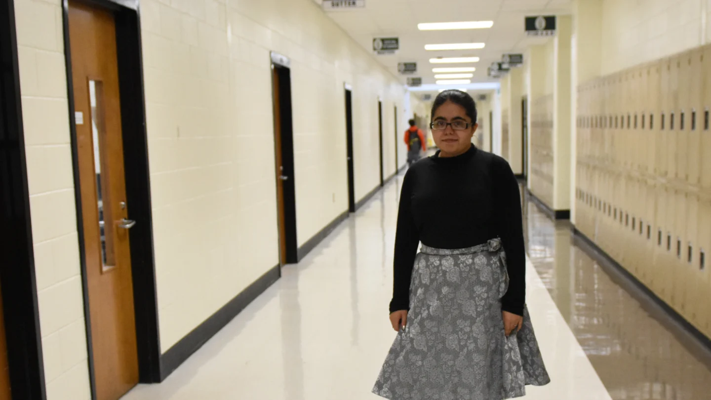 Young girl stands in the hallway at school