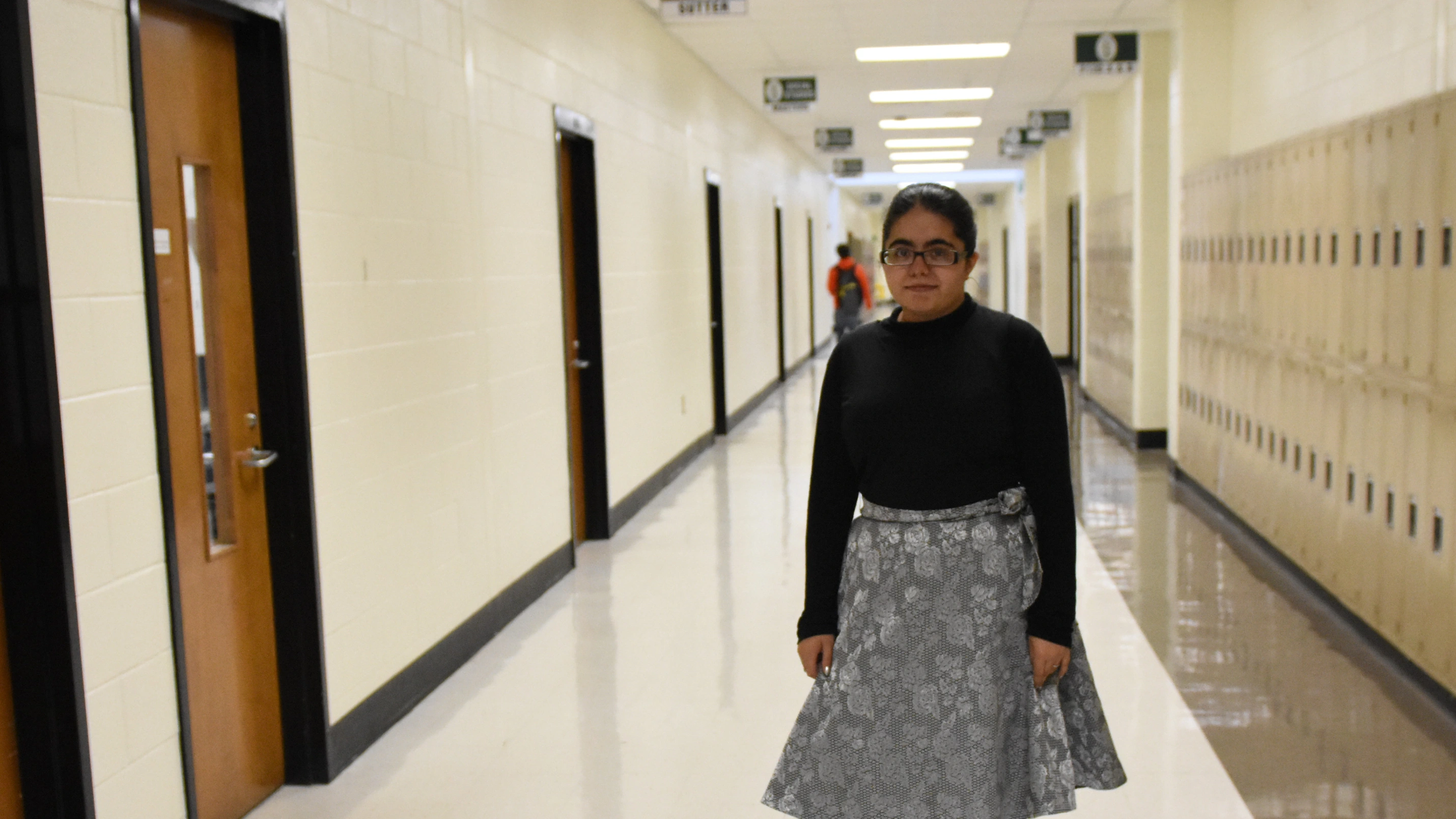Young girl stands in the hallway at school